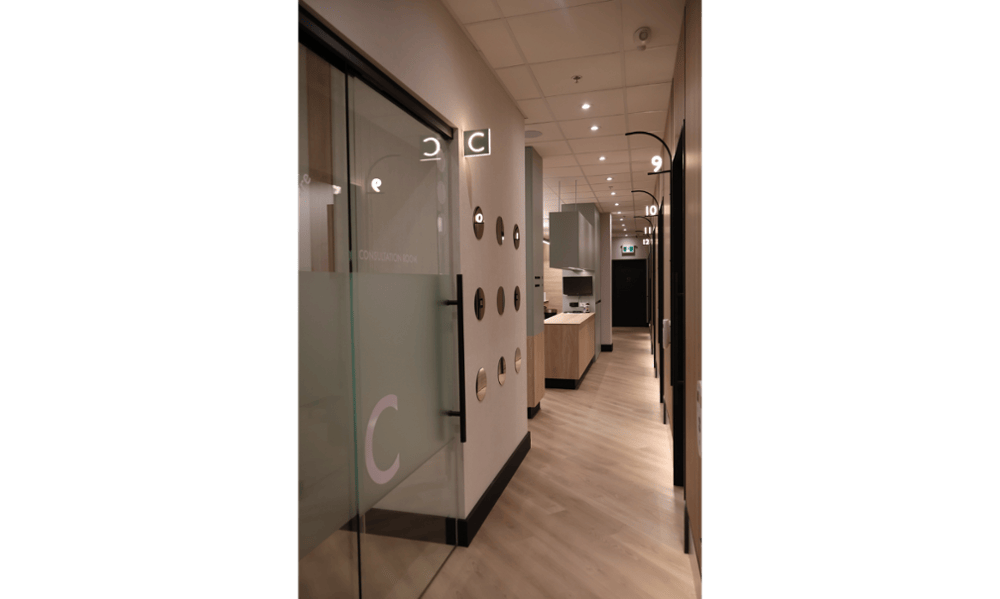 Modern clinical hallway with consultation room and treatment room signage at Smilehaus Newmarket